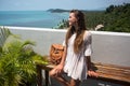 The young quite stylish sensual woman posing on the amazing tropical beach with the blue ocean enjoy her holiday and a windy summe Royalty Free Stock Photo