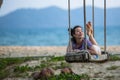 Young race woman lies on the swings on sea beach.