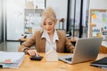 Young real estate agent worker working with laptop and tablet at table in office and small house beside it Royalty Free Stock Photo