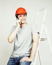 Young real hard worker man isolated on white background on ladder smiling posing, business concept Royalty Free Stock Photo