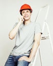 Young real hard worker man isolated on white background on ladder smiling posing, business concept Royalty Free Stock Photo