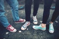 Young rebel teenagers wearing casual sneakers, walking on dirty concrete. Canvas shoes and sneakers on female adults Royalty Free Stock Photo