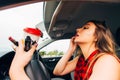 Young reckless girl in car doing make up