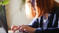 Young red hair officeworker women in glasses is printing on the laptop keyboard. Detail shot Royalty Free Stock Photo