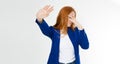 Young red hair woman making a rejection pose and facepalm on a white background. Negative human emotion face expression feeling
