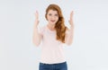 Young red hair woman in a pink shirt, hands shows a frame near the face Royalty Free Stock Photo