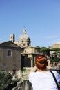 Young red hair woman take photo with smartphone to the Imperial Forums Fori Imperiali in Rome