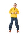 Young red-haired boy in a yellow jacket jumping boy with hands clenched in a fist and raised his thumb up Royalty Free Stock Photo