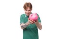 a young red-haired caucasian guy in a green t-shirt is about to empty his piggy bank Royalty Free Stock Photo