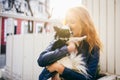 A young red-haired Caucasian woman holds a small funny dog in the arms of two colors of black and white chihuahua. Hugs and kisses Royalty Free Stock Photo