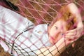 Young red-haired female relaxing in hammock