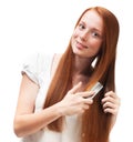 Young red-haired girl combing her long hair. Isolated on white b Royalty Free Stock Photo