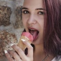 Young red-haired girl juicy licking ice cream with red tongue wi