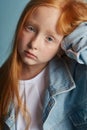 Young red-haired girl with long beautiful hair and big blue eyes. Hair the color of fire fluttering in the wind. Girl child with a Royalty Free Stock Photo