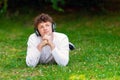 Young red-haired man in headphones lies on the green grass Royalty Free Stock Photo