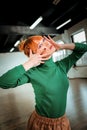 Young red-haired professional choreographer with bright makeup looking good