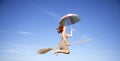 Young red-haired witch on broom flying in the sky Royalty Free Stock Photo