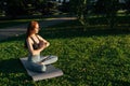 Young red-haired woman with closed eyes in sportswear sitting in lotus position doing yoga exercise Royalty Free Stock Photo