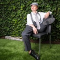 Young red-haired woman dressed as a man on a chair in the garde Royalty Free Stock Photo