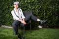 Young red-haired woman dressed as a man on a chair in the garde Royalty Free Stock Photo