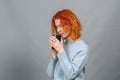 Young red-haired woman with a drink with closed eyes from pleasure, Side view Royalty Free Stock Photo