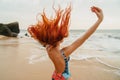 Young red-haired woman with flying hair on the ocean, rear view Royalty Free Stock Photo