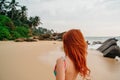 Young red-haired woman with flying hair on the ocean, rear view Royalty Free Stock Photo