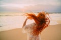 Young red-haired woman with flying hair on the ocean, rear view Royalty Free Stock Photo