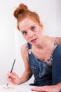 Young red-haired woman paints in her spare time