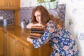 Young red-haired woman relaxing at home with books. Quarantine, isolation, coronavirus pandemic world. Stay at home. Royalty Free Stock Photo