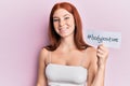 Young red head girl holding bodypositive banner looking positive and happy standing and smiling with a confident smile showing Royalty Free Stock Photo