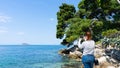 Young red head woman taking picture with smart phone to the blue adriatic sea clean and transparent water in holiday summer coast
