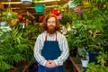 young redhaired ginger bearded man in apron working in the garden or plantation