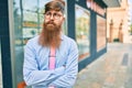 Young redhead businessman with serious expression and crossed arms standing at the city Royalty Free Stock Photo