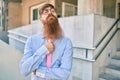 Young redhead businessman with serious expression and crossed arms standing at the city Royalty Free Stock Photo