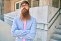 Young redhead businessman with serious expression and crossed arms standing at the city Royalty Free Stock Photo