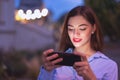 Young redhead businesswoman communicating by smartphone at evening in city