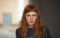 Young redhead caucasian woman serious face outdoor portrait