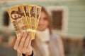 Young redhead girl smiling happy holding hungarian forint banknotes at the city