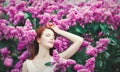 Girl standing near lilac bushes in the park Royalty Free Stock Photo
