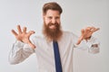 Young redhead irish businessman standing over isolated white background smiling funny doing claw gesture as cat, aggressive and