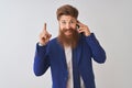 Young redhead irish businessman talking on the smartphone over isolated white background surprised with an idea or question Royalty Free Stock Photo