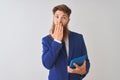 Young redhead irish businessman using tablet over isolated white background cover mouth with hand shocked with shame for mistake, Royalty Free Stock Photo