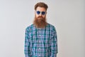 Young redhead irish man wearing casual shirt and sunglasses over isolated white background depressed and worry for distress, Royalty Free Stock Photo
