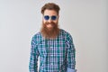 Young redhead irish man wearing casual shirt and sunglasses over isolated white background with a happy and cool smile on face Royalty Free Stock Photo