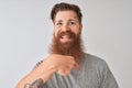 Young redhead irish man wearing t-shirt standing over isolated grey background with surprise face pointing finger to himself Royalty Free Stock Photo