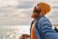 Young redhead man breathing at seaside