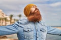 Young redhead man breathing at seaside