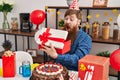 Young redhead man celebrating birthday unpacking gift at home Royalty Free Stock Photo