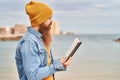 Young redhead man reading book at seaside Royalty Free Stock Photo